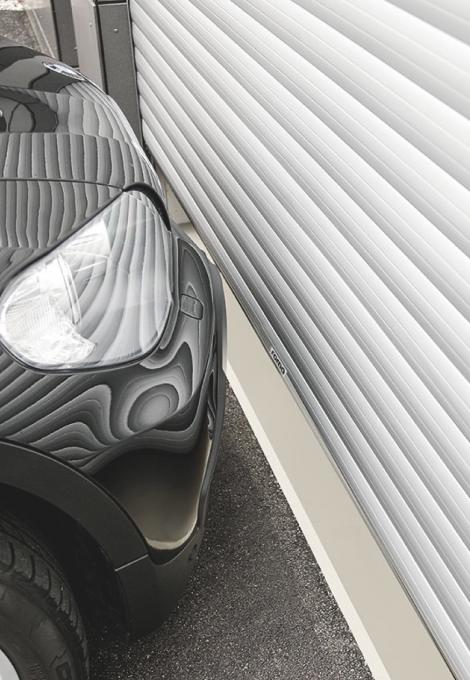 Vue latérale partie d'une voiture BMW série 1 devant porte de garage