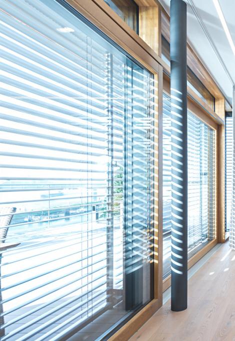 Baie vitrée, le jour, de l'intérieur avec des brise-soleil descendus, position d'inclinaison 90°