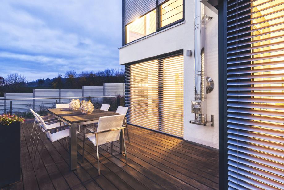 Terrasse avec mobilier d'extérieur, au crépuscule, avec vue sur brise-soleil ROMA à moitié inclinés