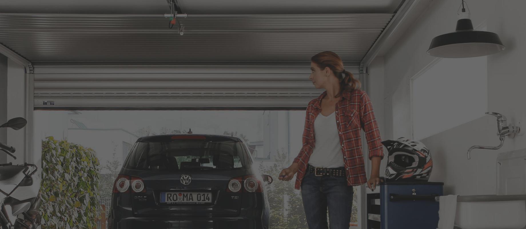 Femme est dans le garage et ferme le porte à l'aide d'une télécommande