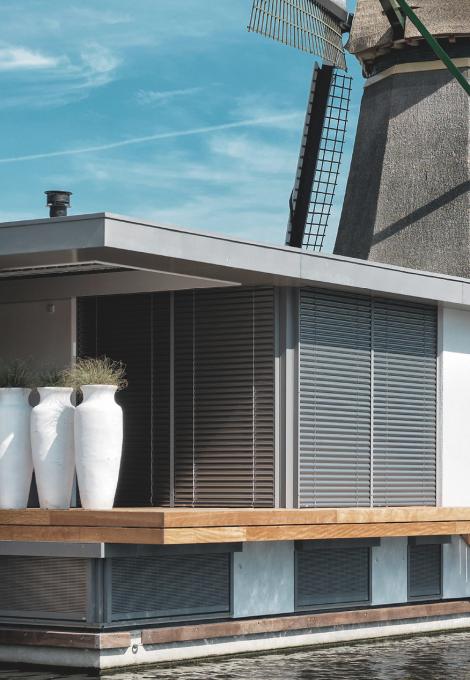 Péniche, vue détaillée, le jour, moulin à vent en arrière-plan, brise-soleil descendus