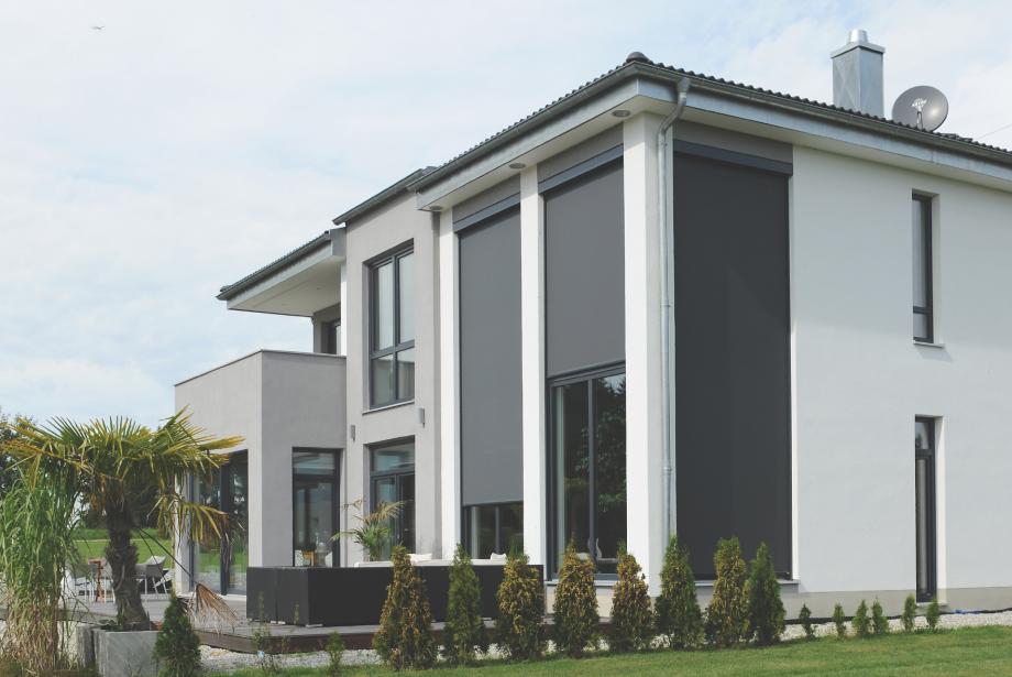 Maison individuelle avec jardin, le jour, stores toiles en partie baissés