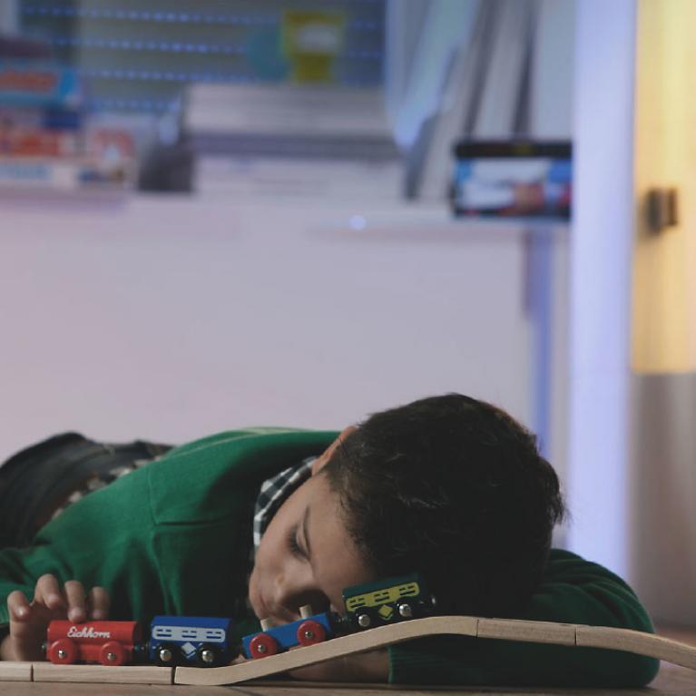 Enfant est couché sur le sol avec chemin de fer, endormi