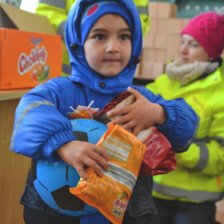 Enfant tenant fort des cadeaux dans les bras