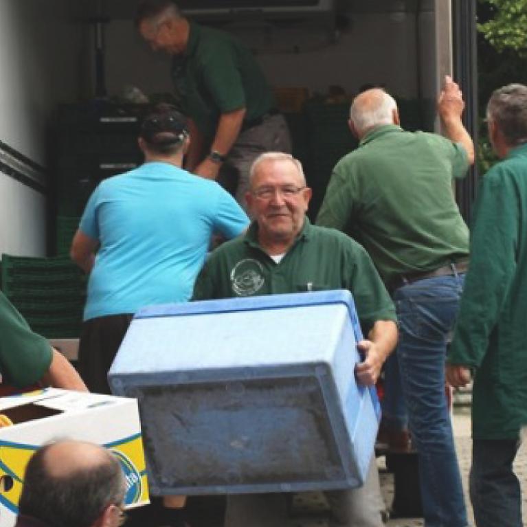 Extrait d'une image, plusieurs hommes déchargent un camion