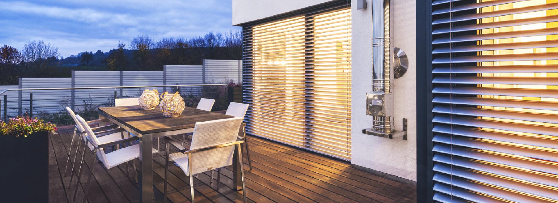 Terrasse avec mobilier d'extérieur, au crépuscule, avec vue sur brise-soleil