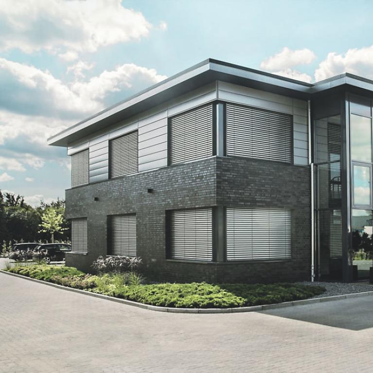 Immeuble de bureaux, le jour, brise-soleil descendus