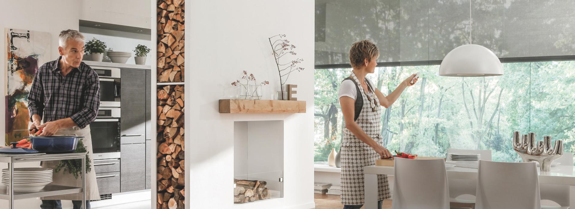 Cuisine ouverte, femme commande les stores toiles à l'aide d'une télécommande