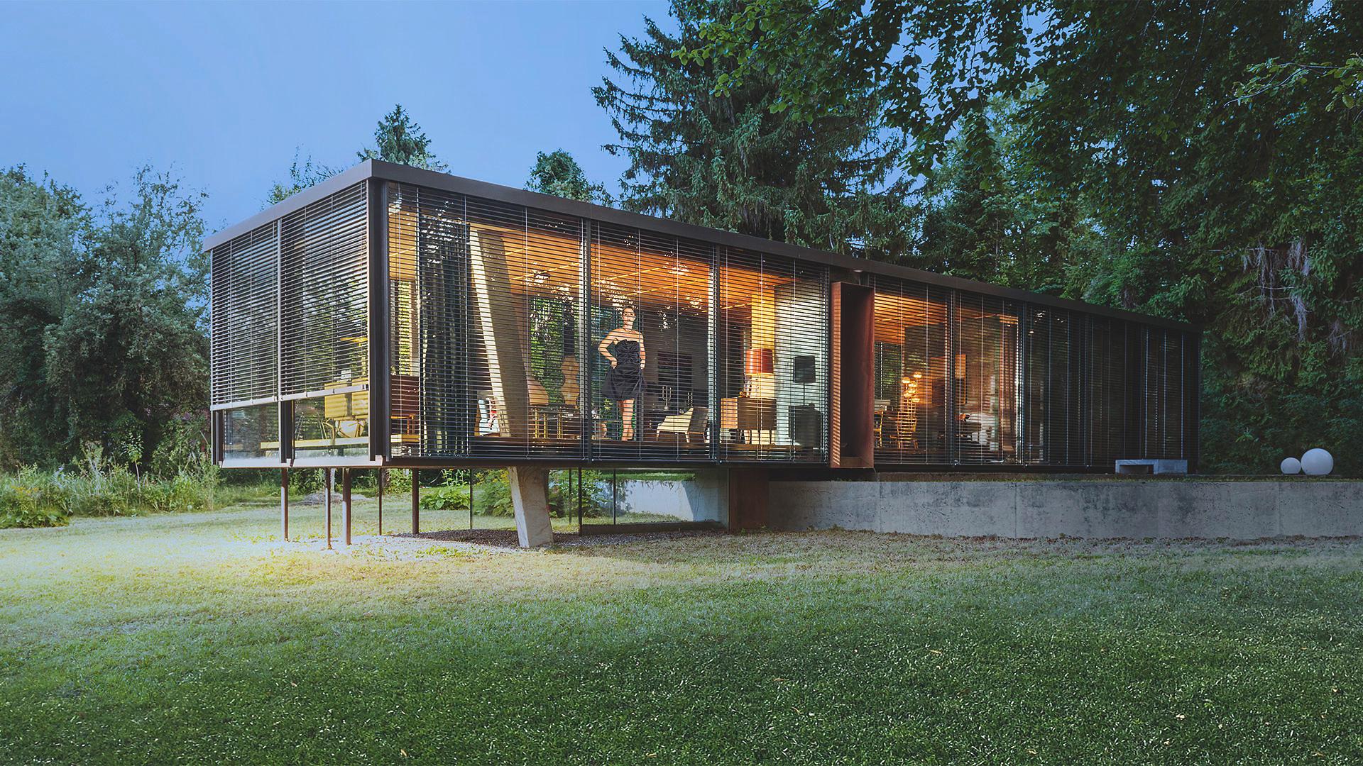 Bungalow vitré moderne sur pilotis, le jour, avec brise-soleil, en pleine nature