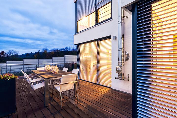 Terrasse avec mobilier d'extérieur, au crépuscule, avec vue sur brise-soleil