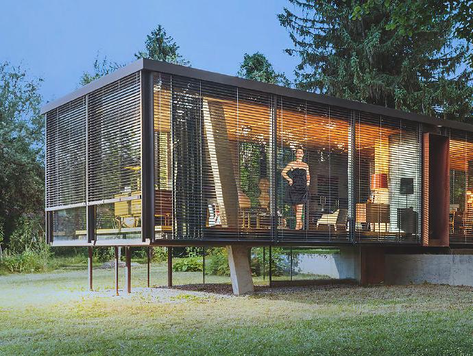 Bungalow vitré moderne sur pilotis, le jour, avec brise-soleil, en pleine nature