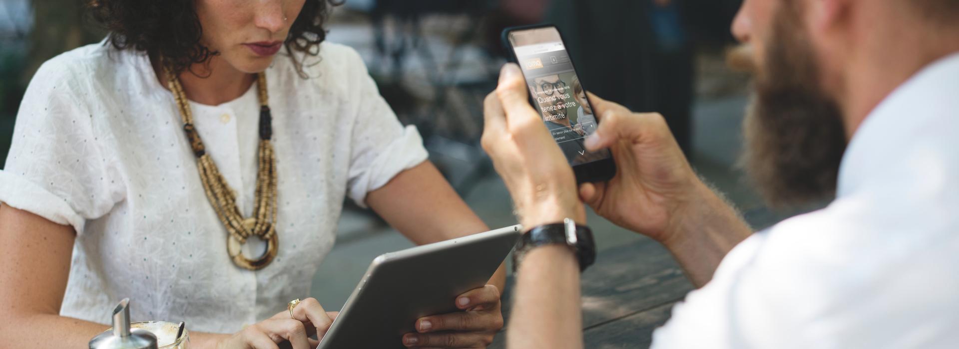 Femme et homme dans un café avec des appareils mobiles