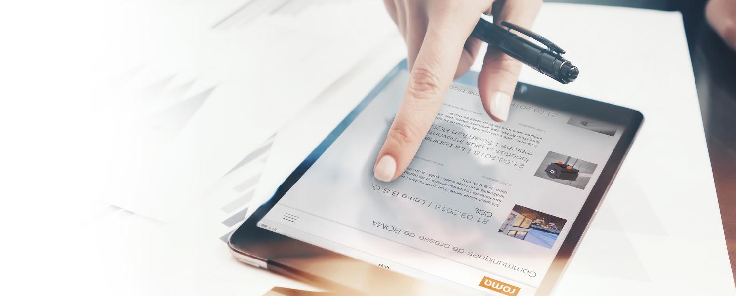 Main avec stylo à bille passe avec l'index sur la tablette, communiqués de presse ROMA