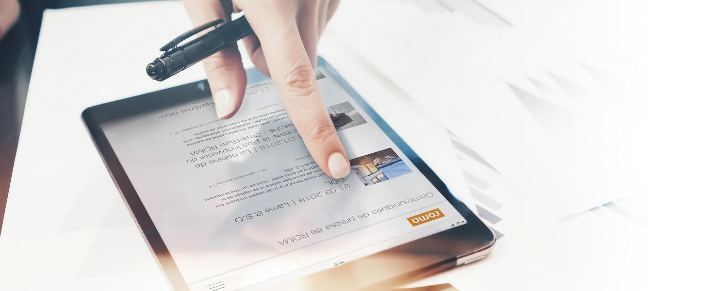 Main avec stylo à bille passe avec l'index sur la tablette, communiqués de presse ROMA