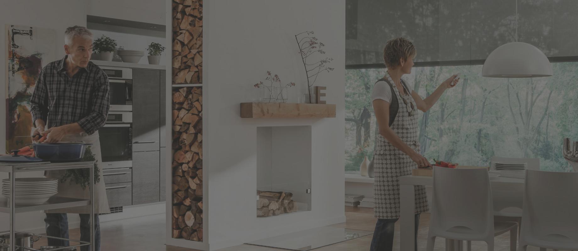 Cuisine ouverte, femme commande les stores toiles à l'aide d'une télécommande