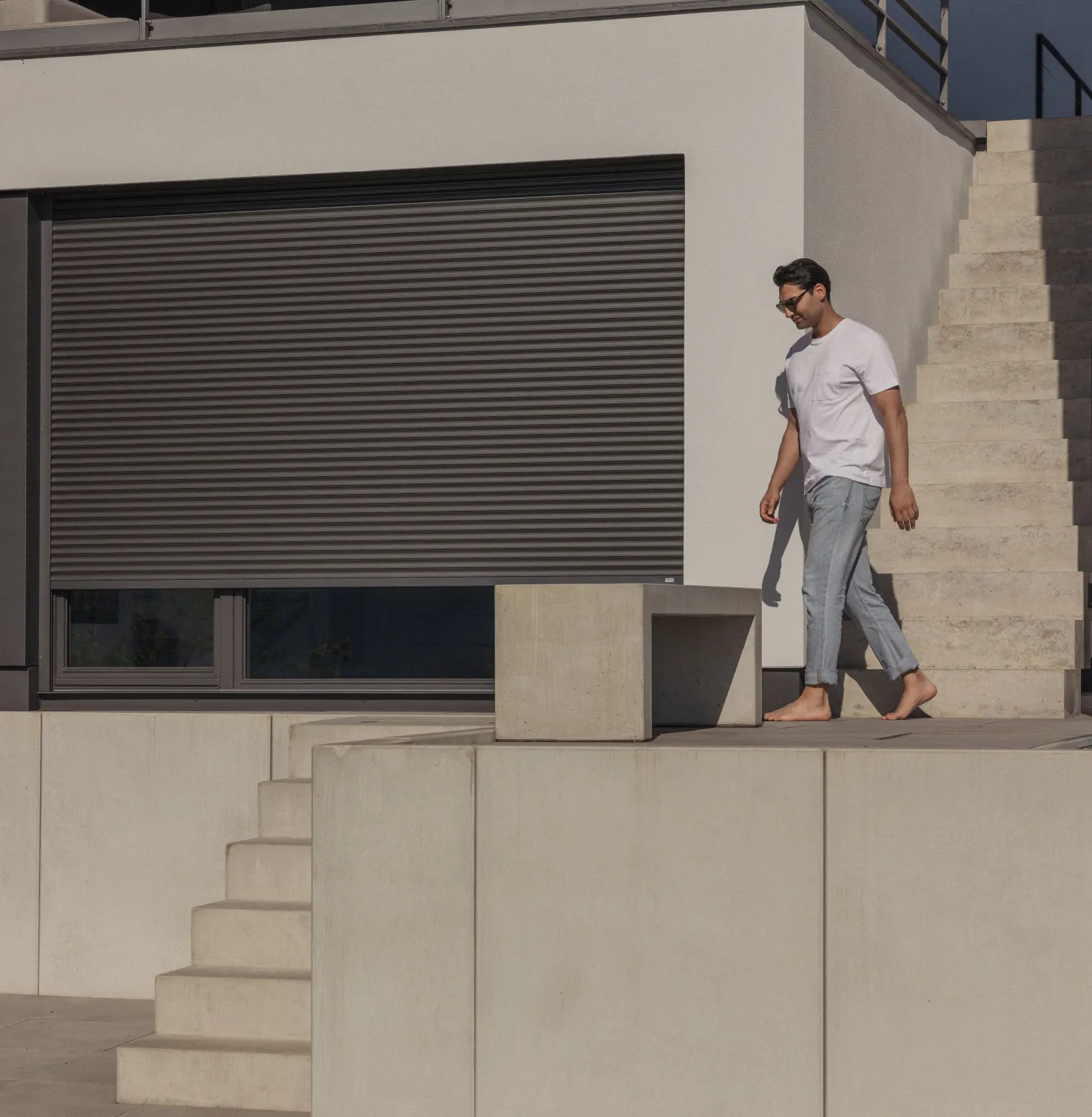 Mann läuft draußen an ROMA Rollladen vorbei