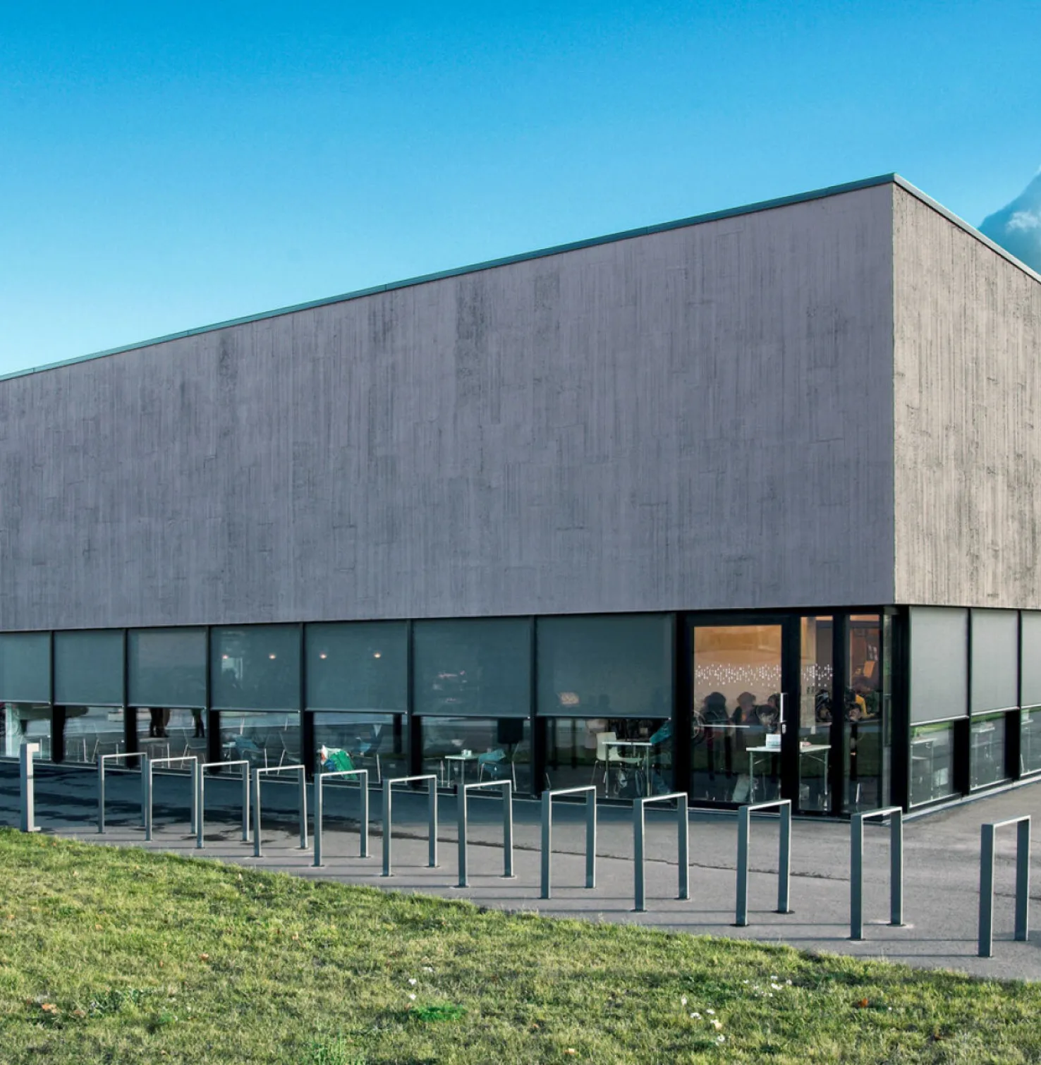 Bâtiment moderne de deux étages avec fenêtres sur tout le pourtour et Stores toiles