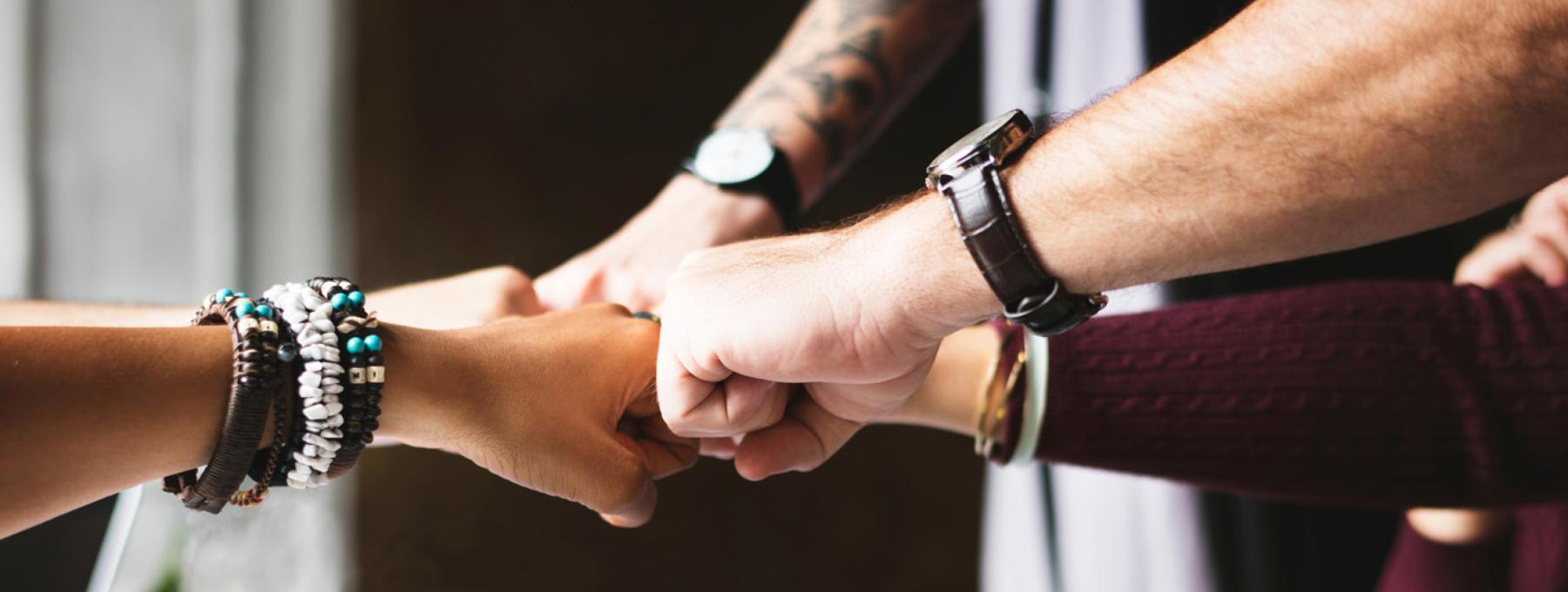 Un groupe de personnes se tient les poings l'un contre l'autre